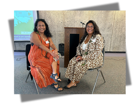 An image of two women sitting and smiling at the camera