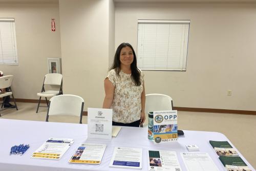 Woman standing behind table smiling 